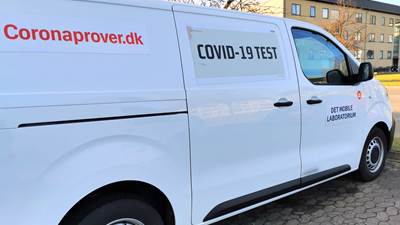 Hvid varebil, hvor der på siden med rød skrift står skrevet "Coronaprover.dk" og COVID-19 TEST