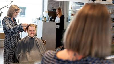 Erhvervsminister Simon Kollerup bliver klippet af en frisør i en salon