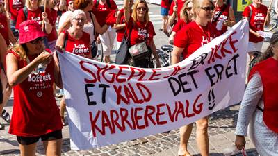 Konfliktramte sygeplejersker ved demonstration på Rådhuspladsen i København. De forreste holder et banner med teksten "sygepleje er ikke et kald - det er et karrierevalg".