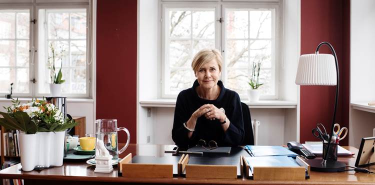 Portræt af Mette Bock forfra, siddende ved hendes skrivebord