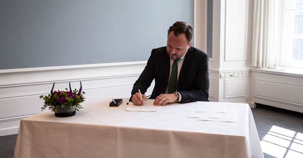 Minister for udviklingssamarbejde og global klimapolitik Dan Jørgensen underskriver løfteerklæring om at overholde grundloven