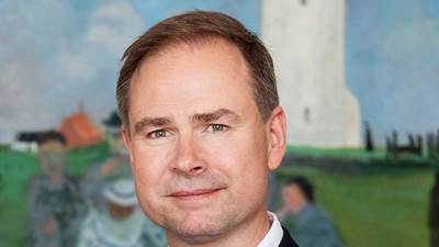 Finansminister Nicolai Wammen med sort blazer og hvid skjorte foran maleri