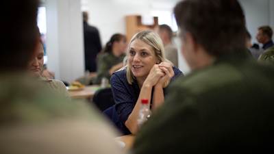 Forsvarsminister Trine Bramsen på base i Litauen. Hun sidder ved et langbord og taler med soldater