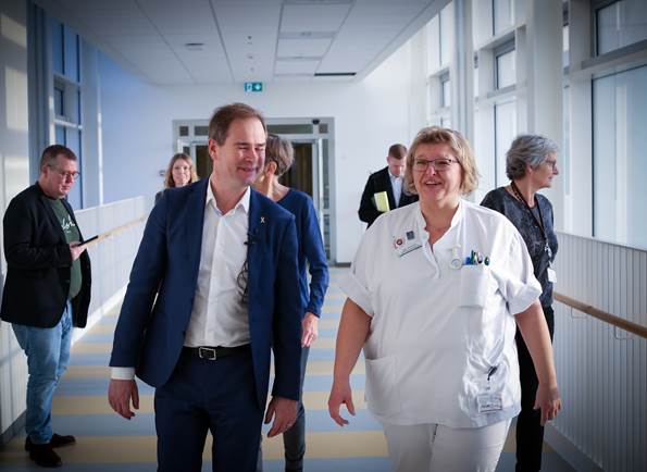Finansminister Nicolai Wammen besøger sygehus. Han går ned af en sygehusgang med sundhedspersonale ved sin side