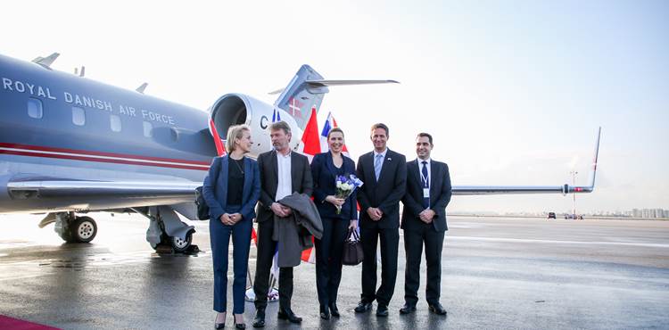 Statsminister Mette Frederiksen og hendes følge foran flyet på vej hjem til Danmark