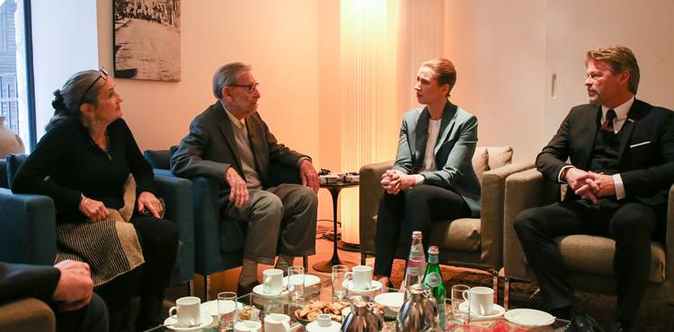 Statsminister Mette Frederiksen sidder og taler med to holocaustoverlevere